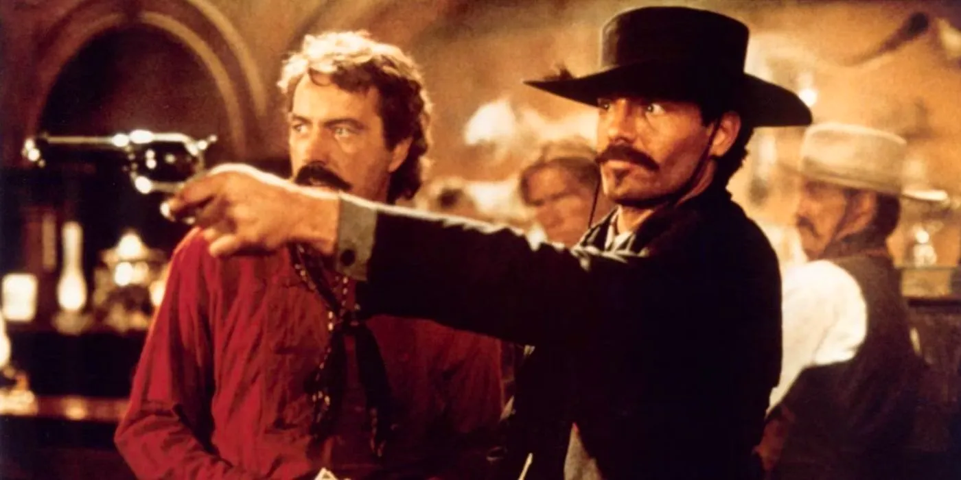 Johnny Ringo aiming a gun in a saloon as Curly Bill watches in Tombstone Image