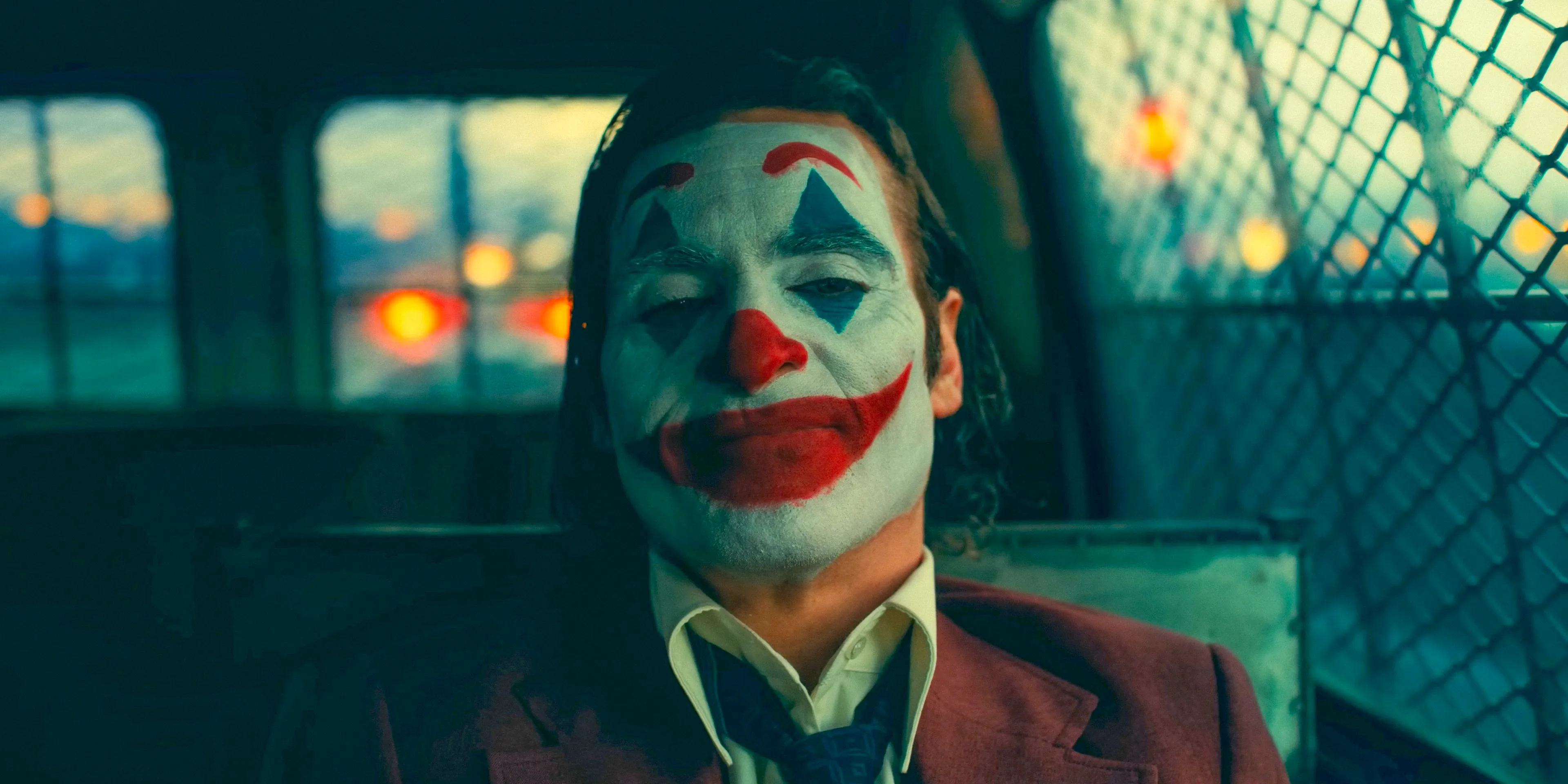 Joker (Joaquin Phoenix) in a security van being transported to prison in Joker: Folie à Deux Image