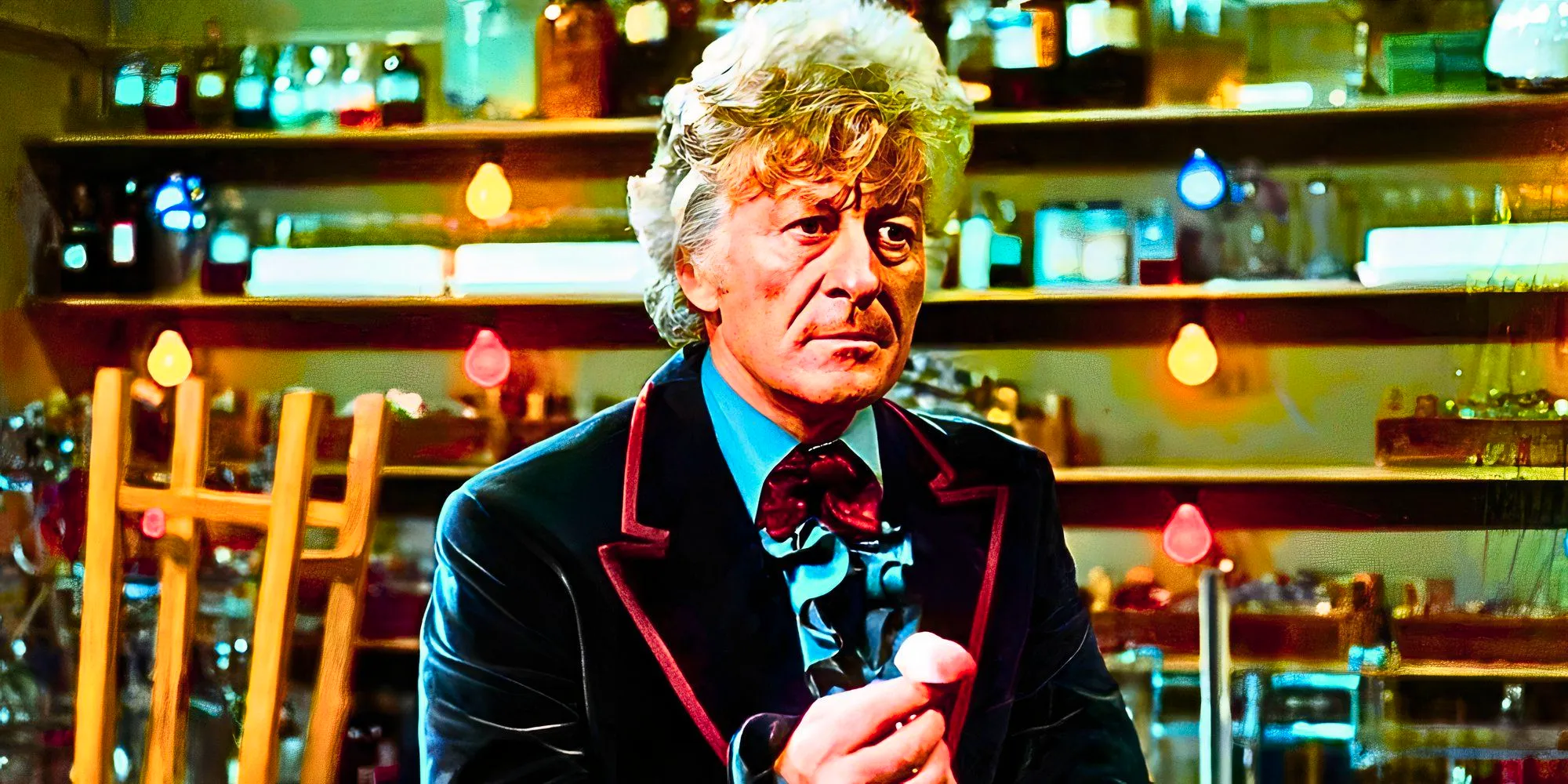 Jon Pertwee as the Third Doctor holding something and looking serious in Doctor Who. Image