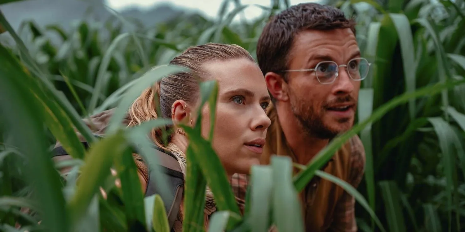 Jonathan Bailey and Scarlett Johansson in long grass in Jurassic World Rebirth Image