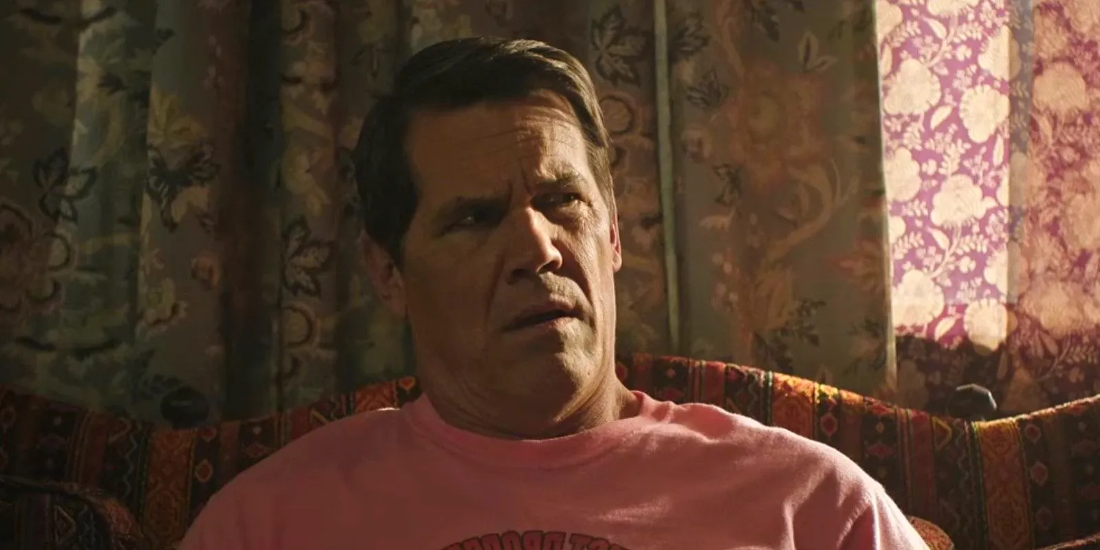 Josh Brolin sitting on a couch looking confused in Brothers Image