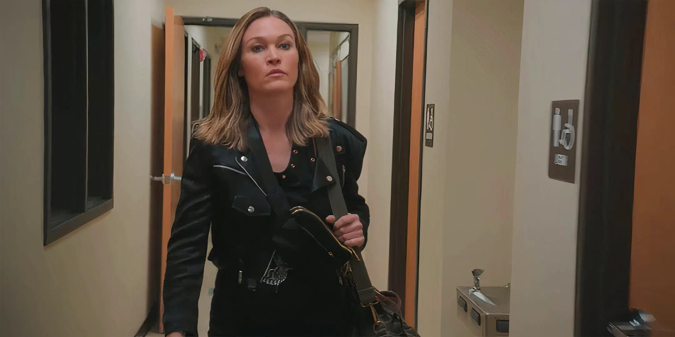 Julia Stiles as Clio looking angry and walking down a hallway in Chosen Family Image