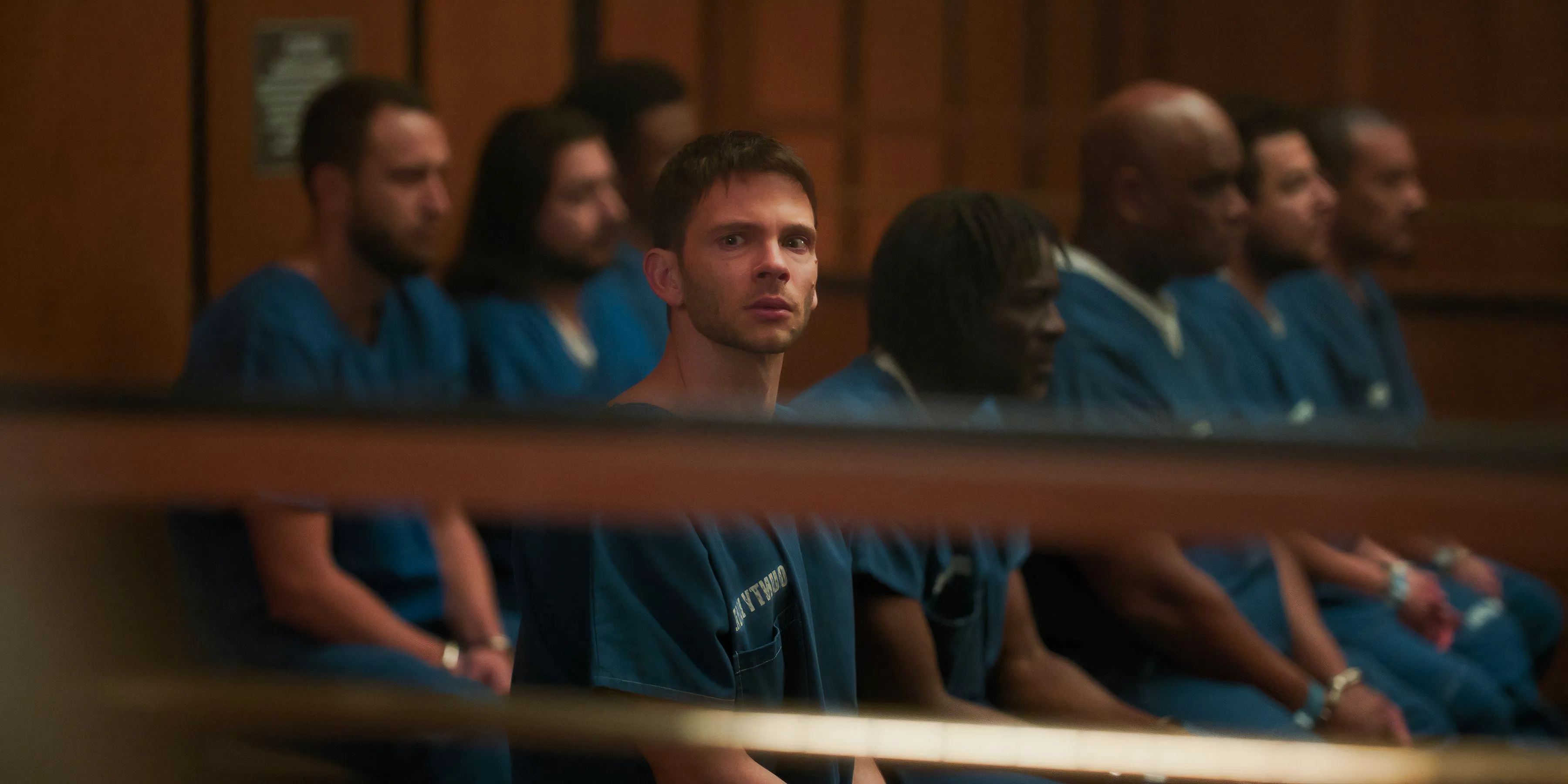 Julian sits with the other inmates in The Lincoln Lawyer season 3 episode 2. Image