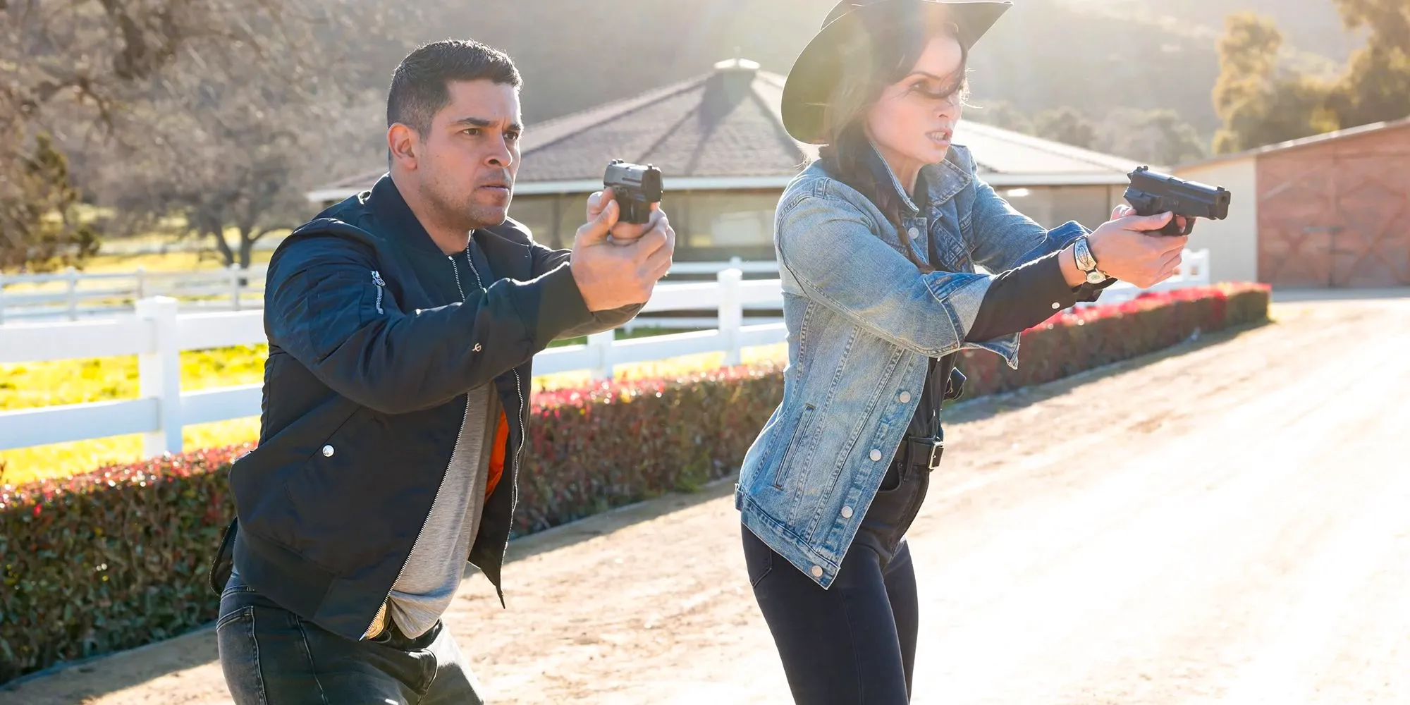 Katrina Law as Jessica Knight and Wilmer Valderrama as Nick Torres with their guns drawn in NCIS Image