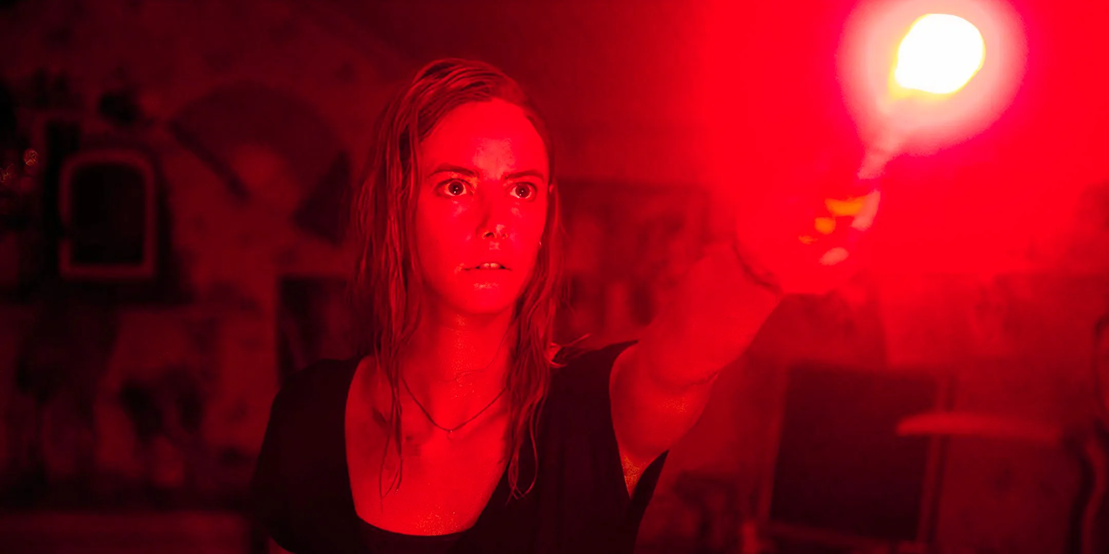 Kaya Scodelario as Haley holding up a flare in Crawl Image