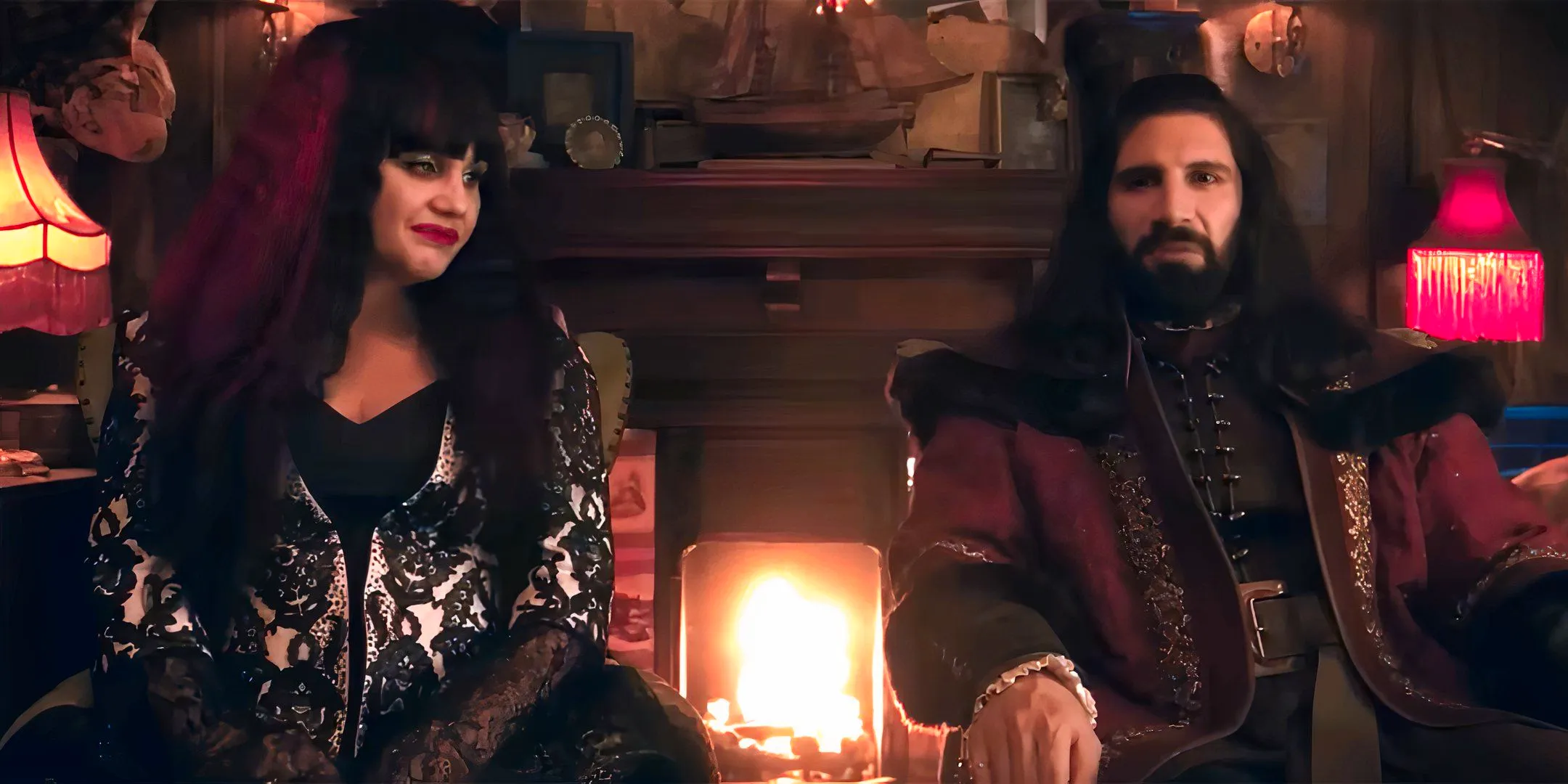 Kayvan Novak's Nandor and Natasia Demetriou's Nadja sitting next to each other and talking to the camera in What We Do in the Shadows season 6 Image