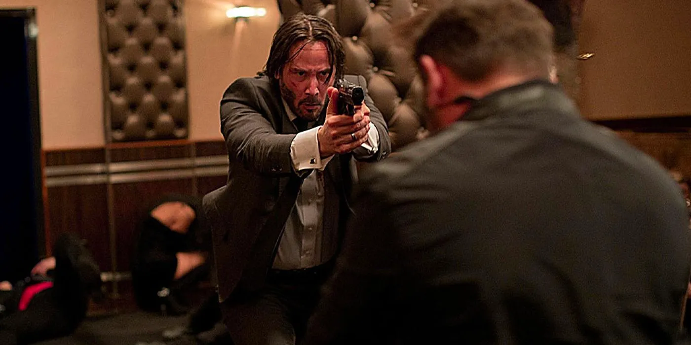 Keanu Reeves as John Wick Holding a Gun Up in John Wick Image