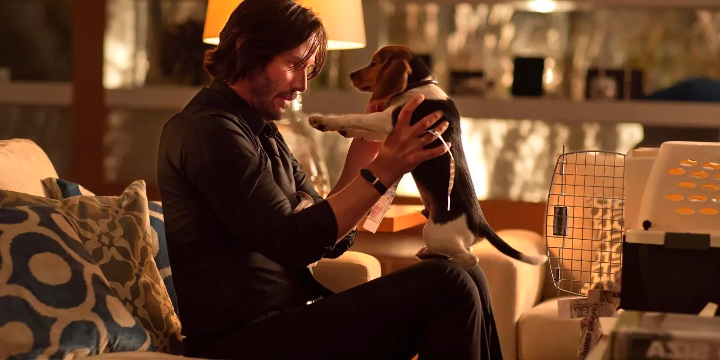 Keanu Reeves as John Wick holds his beloved dog in John Wick. Image