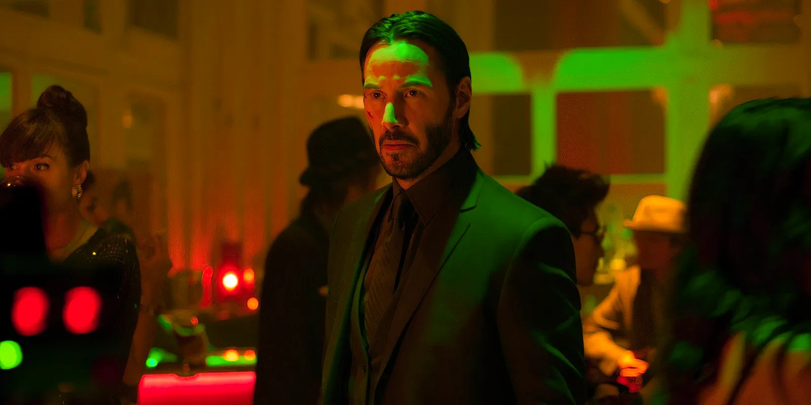 Keanu Reeves standing solemnly as John Wick in John Wick Image