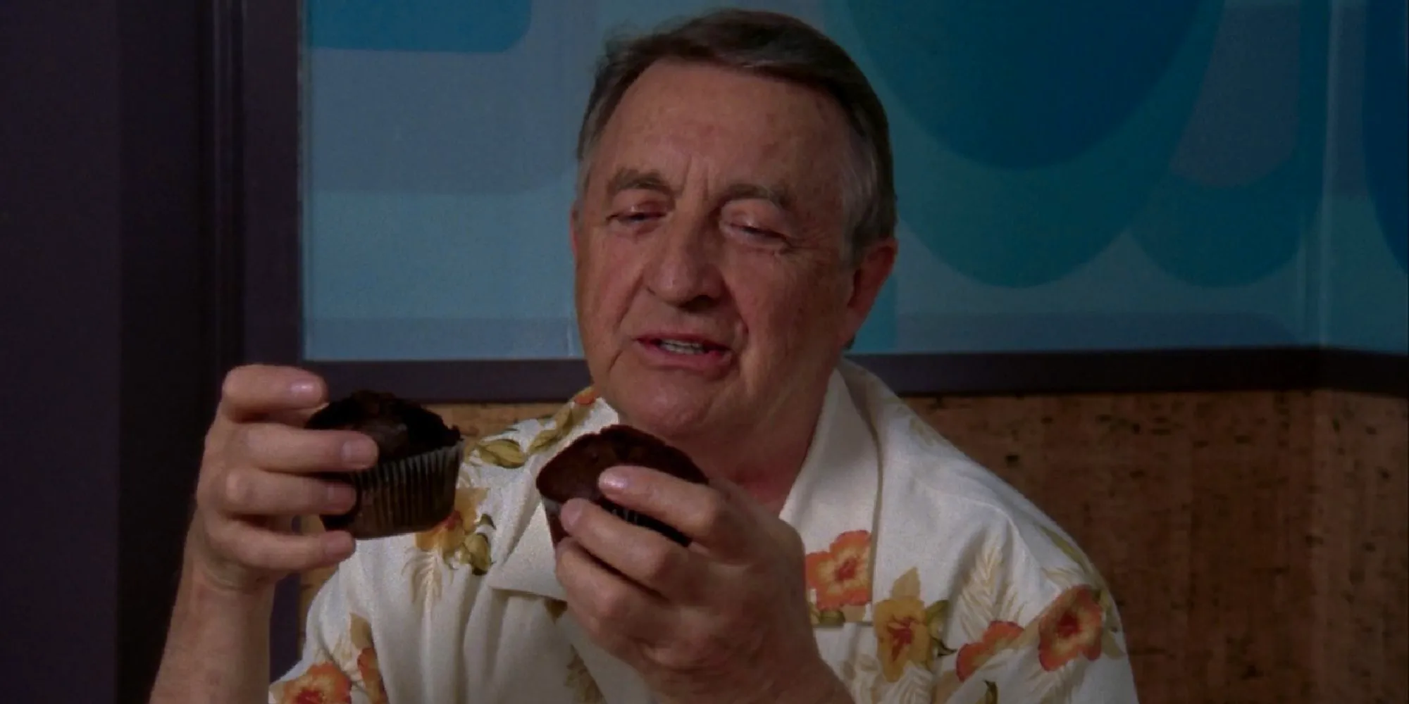 Ken Jenkins as Dr. Kelso holding a muffin in each hand and looking at them longingly in Scrubs Image