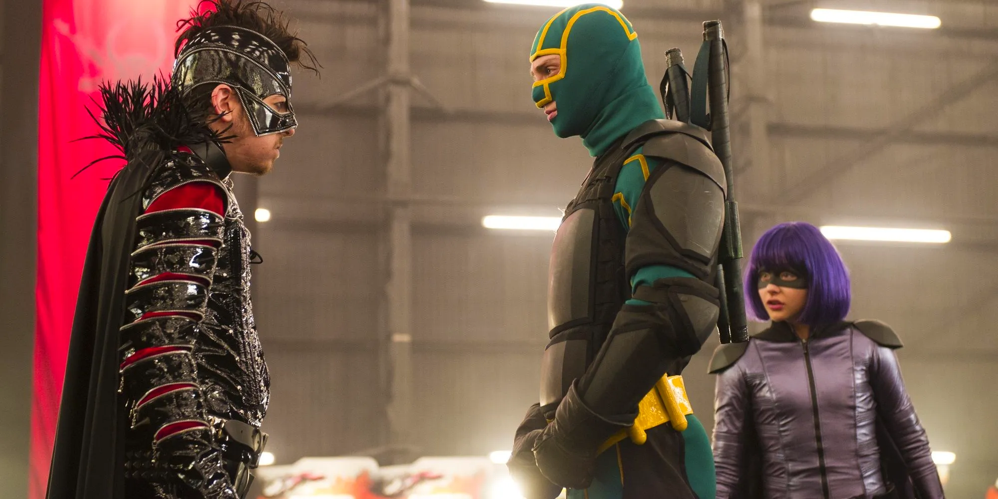 Kick-Ass in his yellow and green suit and Hit-Girl in her purple suit confront Chris in Kick-Ass 2 Image