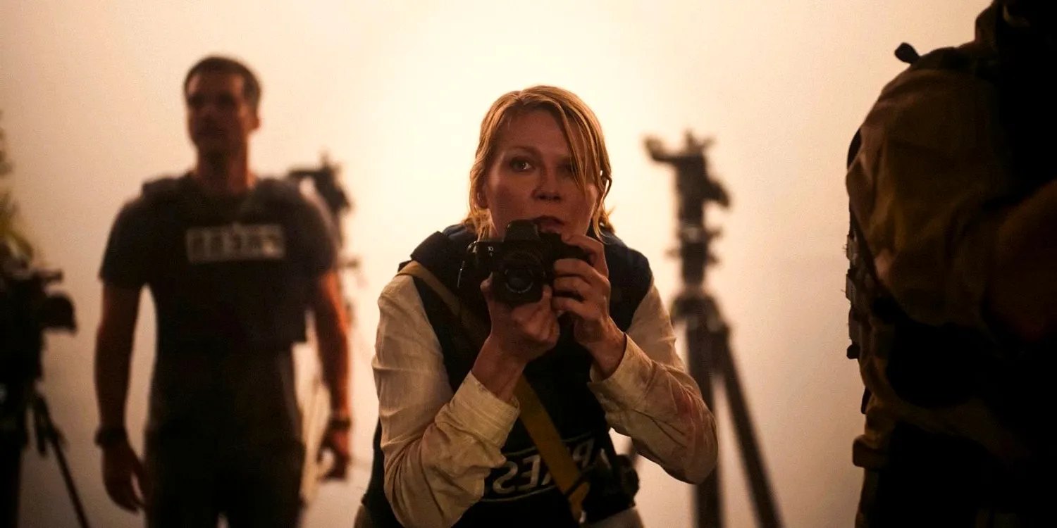 Kirsten Dunst's Lee holds her camera ready to shoot in Civil War Image