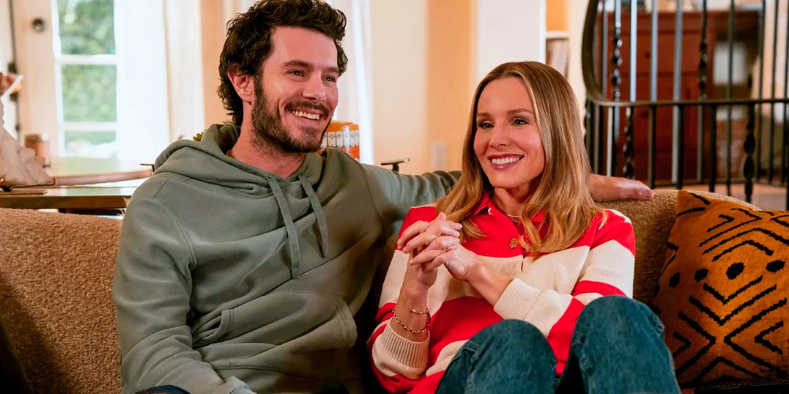 Kristen Bell and Adam Brody sitting on a couch in Nobody Wants This Image