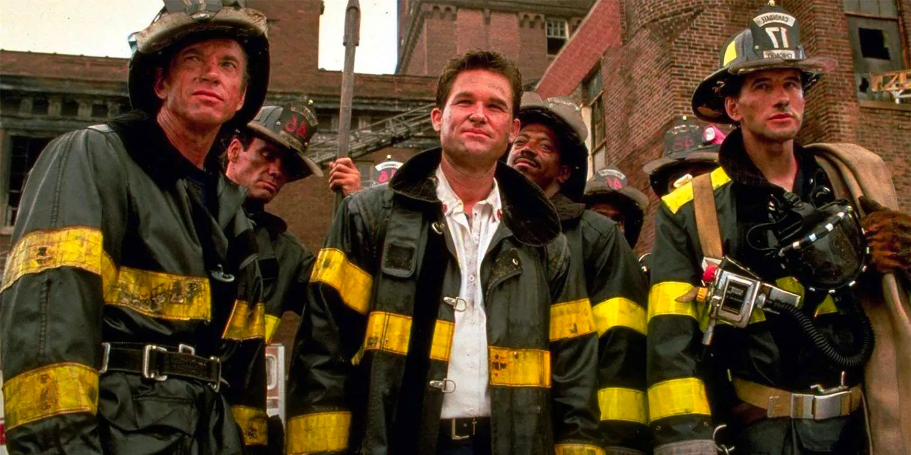 Kurt Russell as Stephen McCaffrey surrounded by other firefighters facing forward and upward in Backdraft. Image