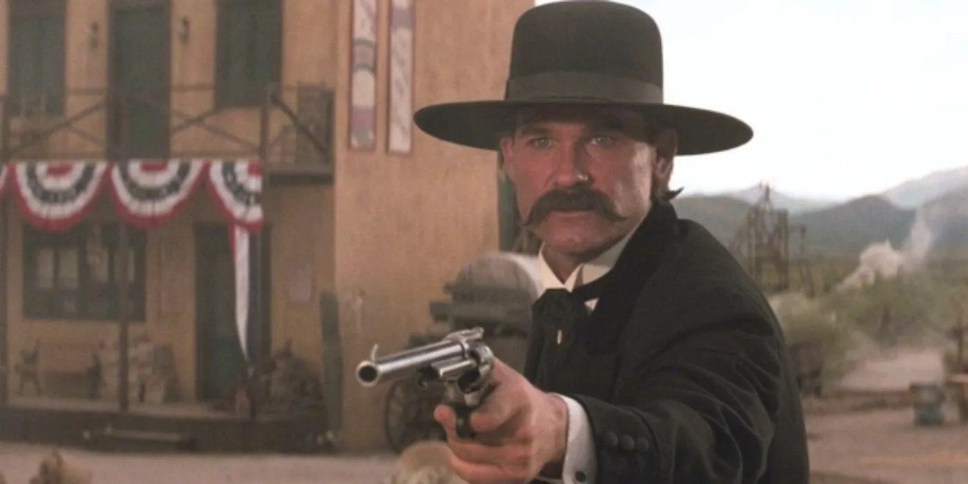 Kurt Russell as Wyatt Earp holding a pistol in Tombstone Image