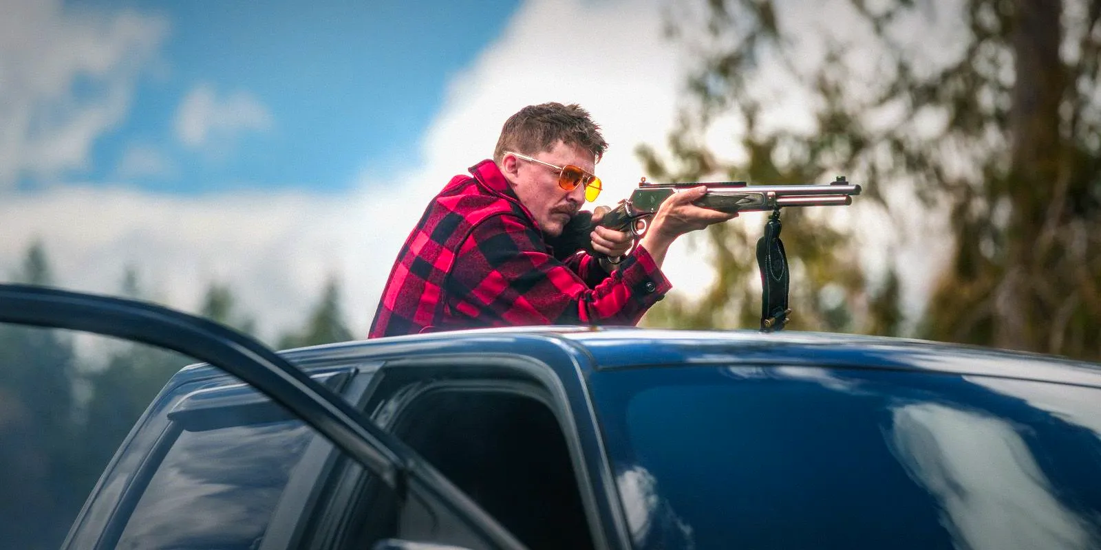 Kyle Gallner as The Demon Aiming a Rifle from On Top of His Truck in Strange Darling Image