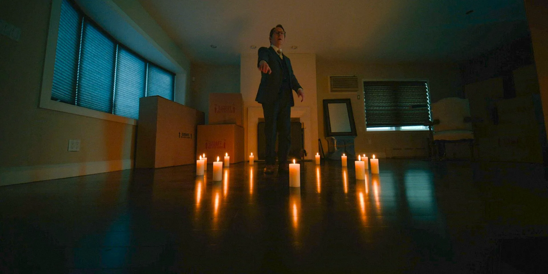 Leland Townsend (Michael Emerson) is surrounded by candles, channeling his powers to influence David's mind in Evil Season 4 Episode 10 Image