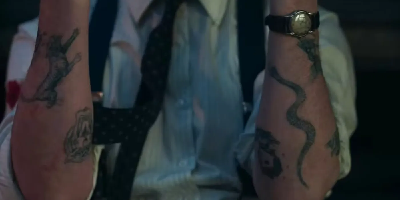 Leonard's tattoos on his arms in The Outfit Image