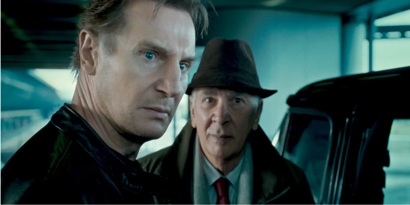 Liam Neeson and Frank Langella with serious expressions in Unknown Image