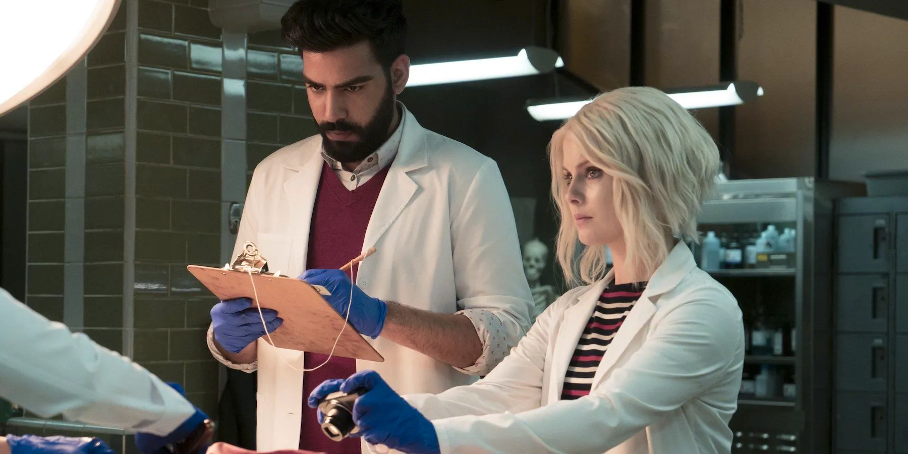 Liv and Rav stand in front of body in the lab in iZombie Season 3 Image