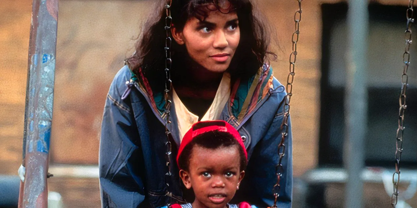 Losing Isaiah Halle Berry, halle stands over isaiah in a loving motherly way pushing him on a swing in a playground Image