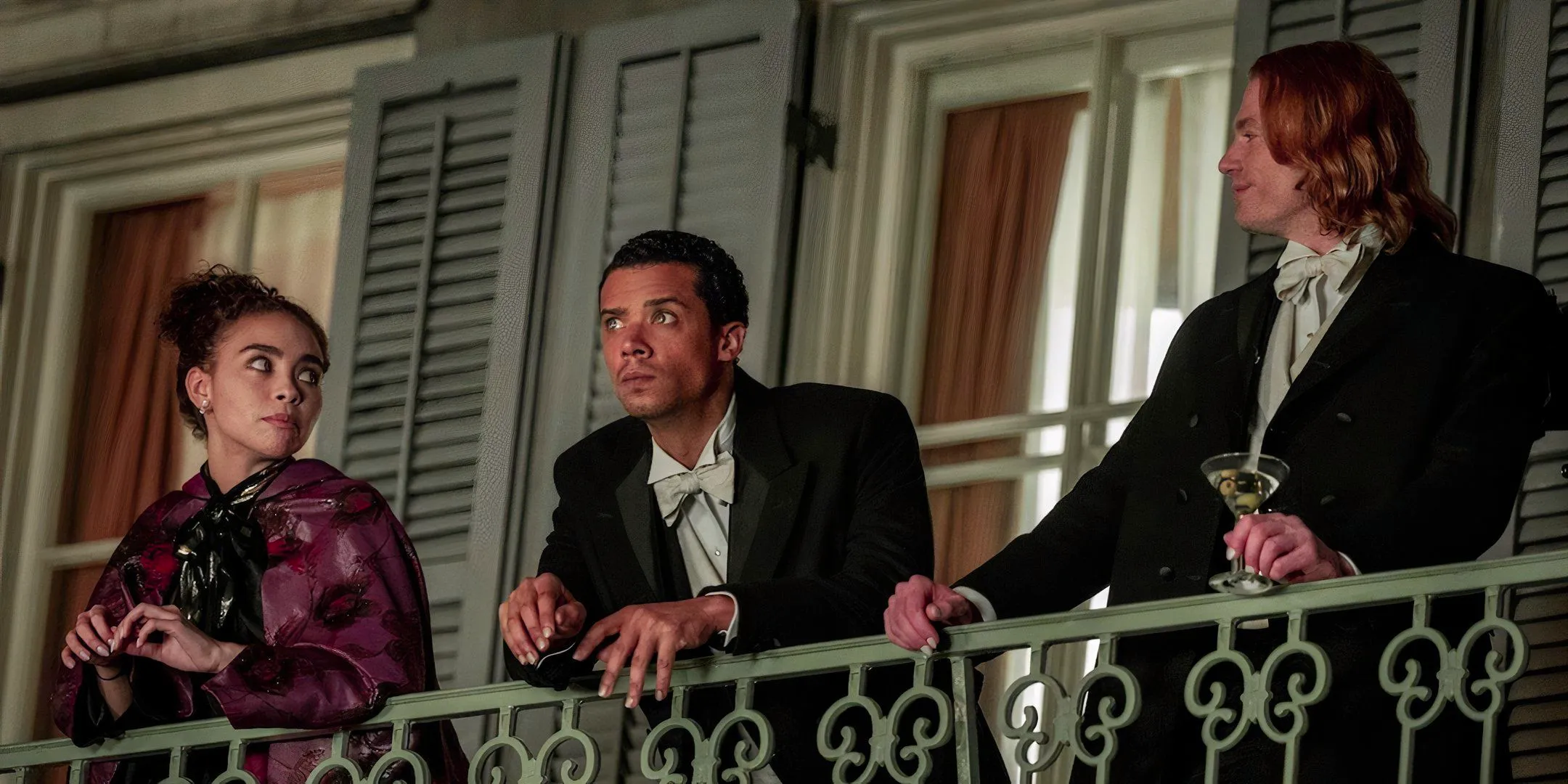 Louis (Jacob Anderson), Lestat (Sam Reid) and Claudia (Bailey Bass) stand on their New Orleans balcony in Interview With The Vampire season 1 Image