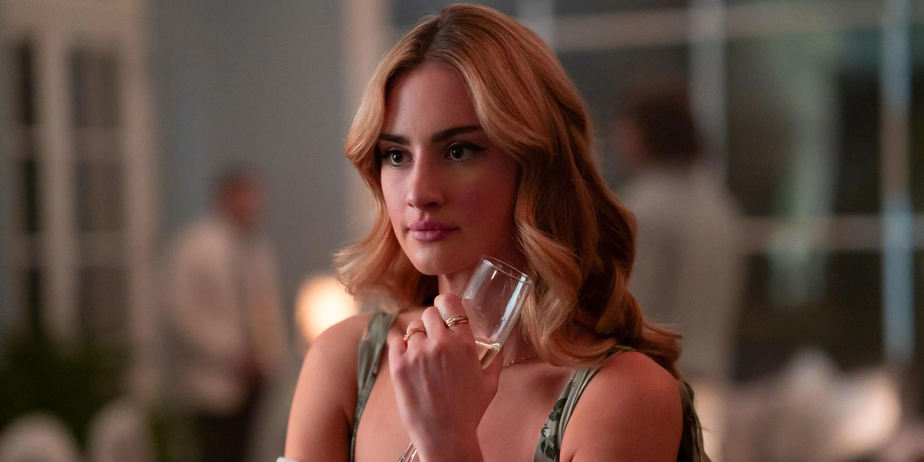 Lucy holding a glass in Tell Me Lies Season 2. Image