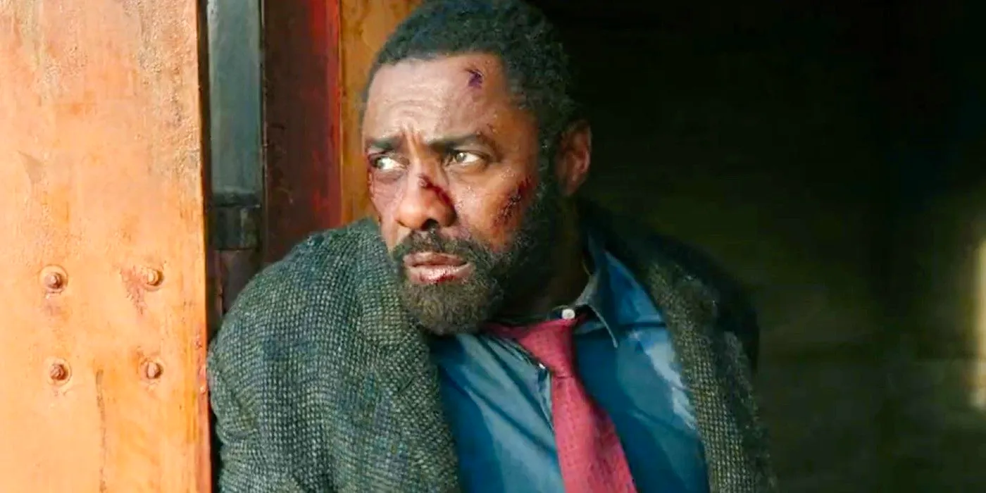 Luther (Idris Elba) looking battered and beat up while hiding behind a wall in Luther Image