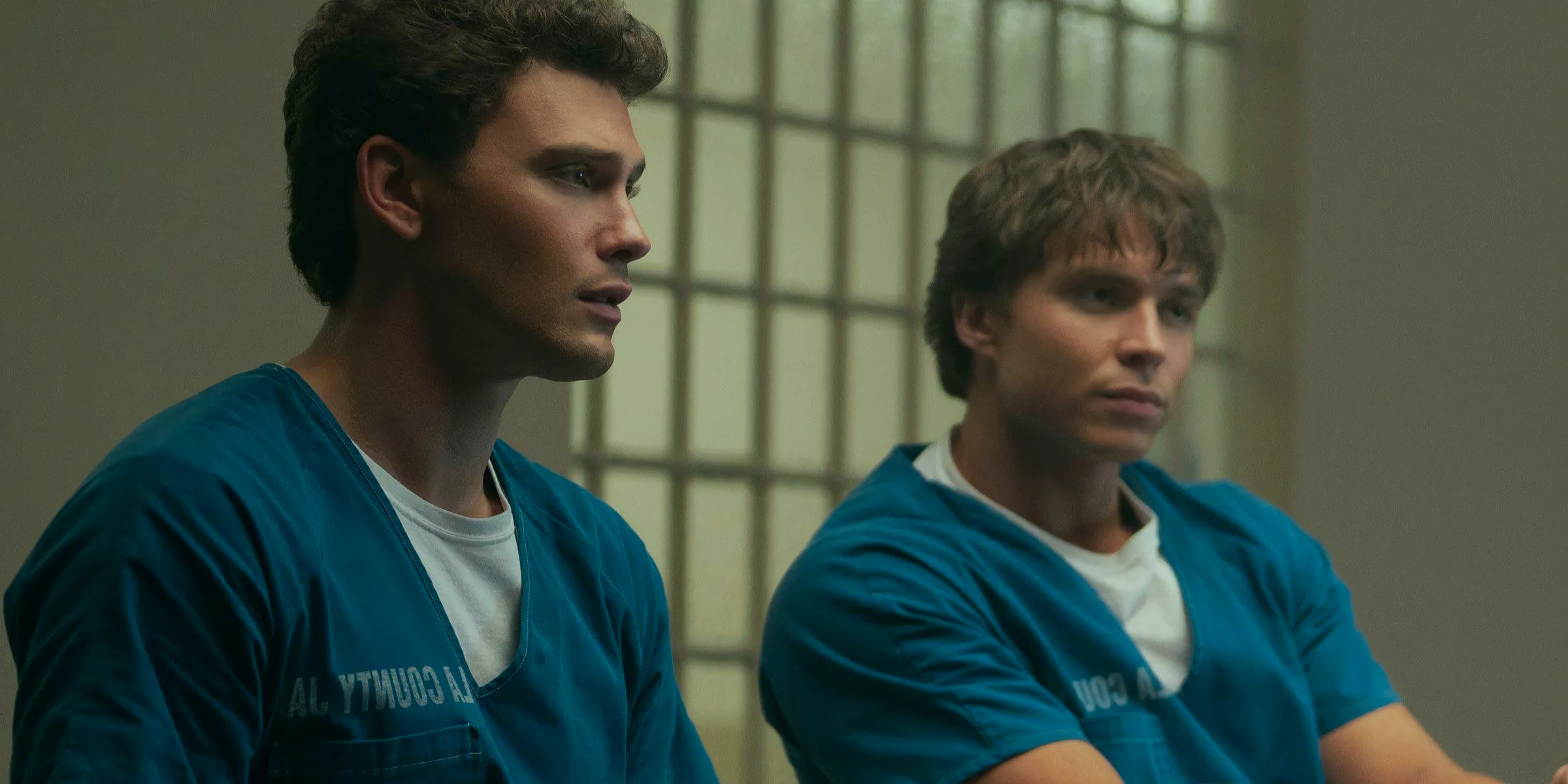 Lyle and Erik Menendez sit in blue jail clothes in Monsters: The Lyle and Erik Menendez Story. Image