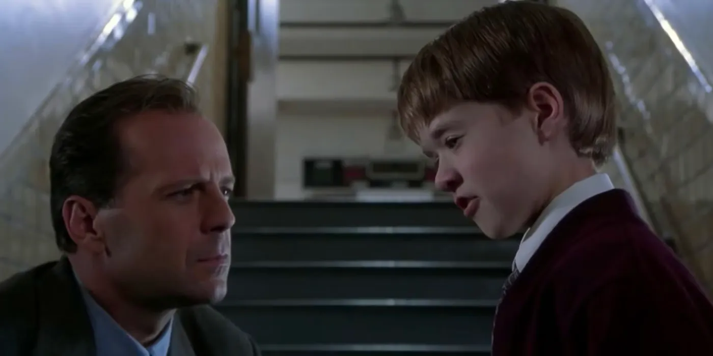 Malcolm (Bruce Willis) leans down to Cole (Haley Joel Osment) in The Sixth Sense  Image