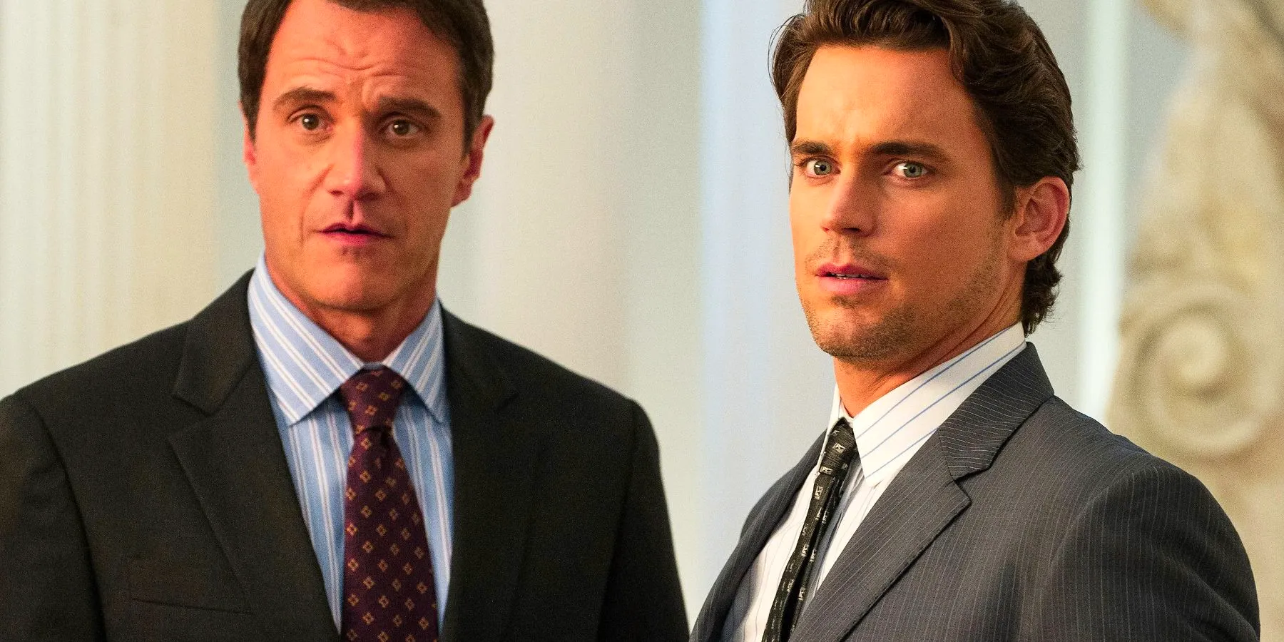 Matt Bomer as Neal Caffrey and Tim Dekay as Peter Burke standing next to each other and appearing amused in White Collar Image