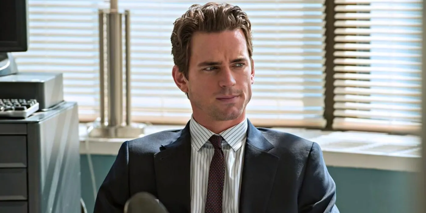 Matt Bomer as Neal Caffrey sitting at a desk and listening intently in White Collar Image