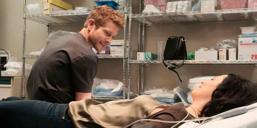 Matt Czuchry as Dr. Conrad Hawkins talking to a female patient in a hospital bed in The Resident Image