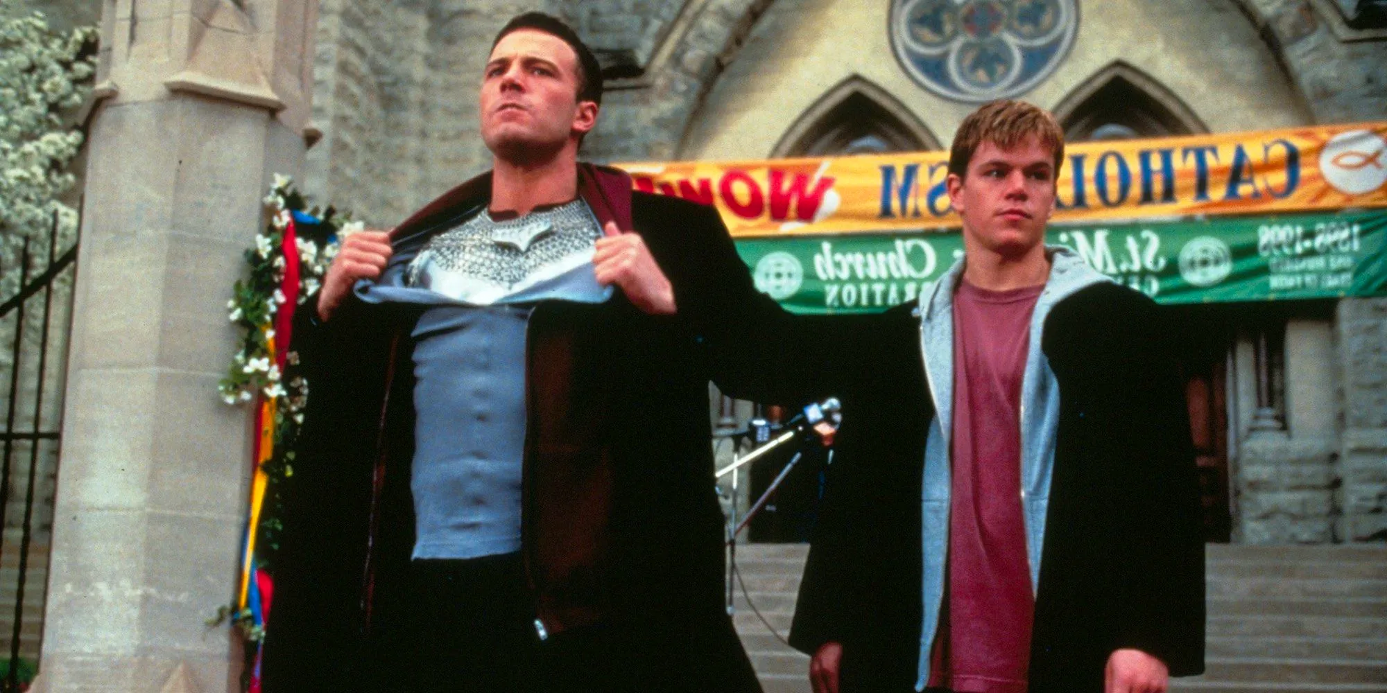 Matt Damon and Ben Affleck stand in front of a church in Dogma Image