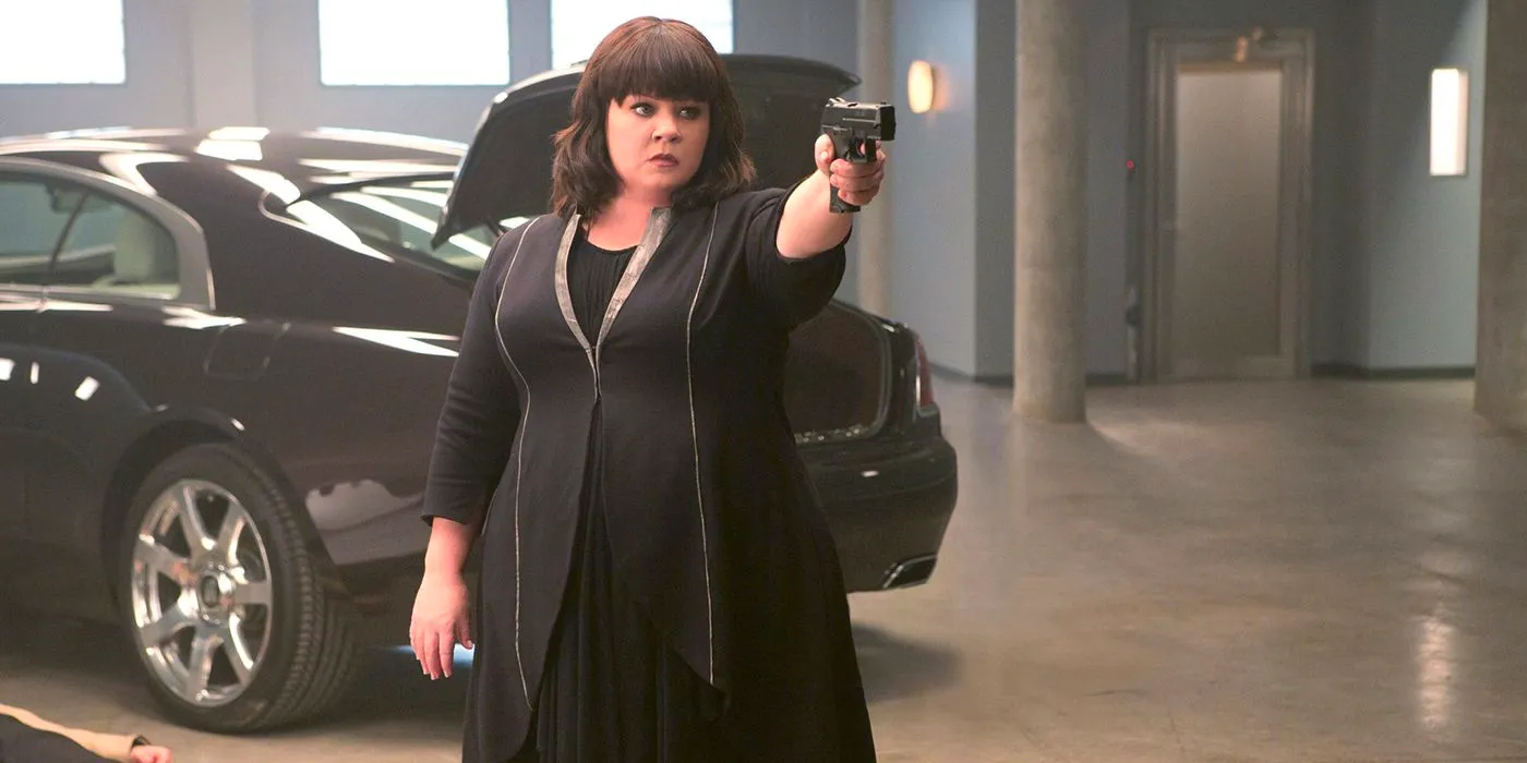 Melissa McCarthy in All Black, Holding and Pointing a Gun in Spy Image