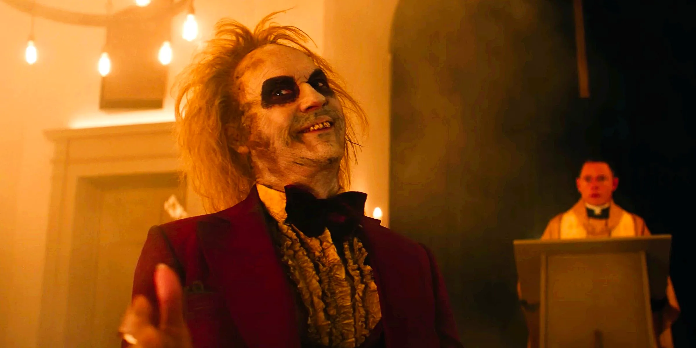 Michael Keaton as Betelgeuse wearing his red tuxedo at his wedding in Beetlejuice 2 Image