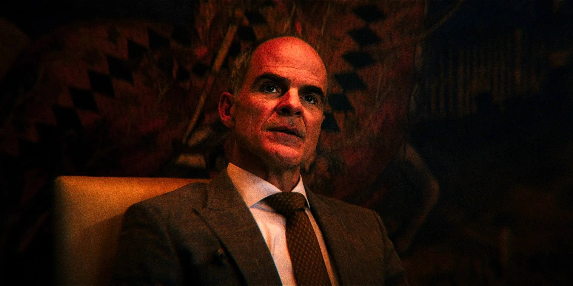 Michael Kelly As Johnny Viti Sitting In A Chair In Front Of A Patterned Wall In The Penguin Image