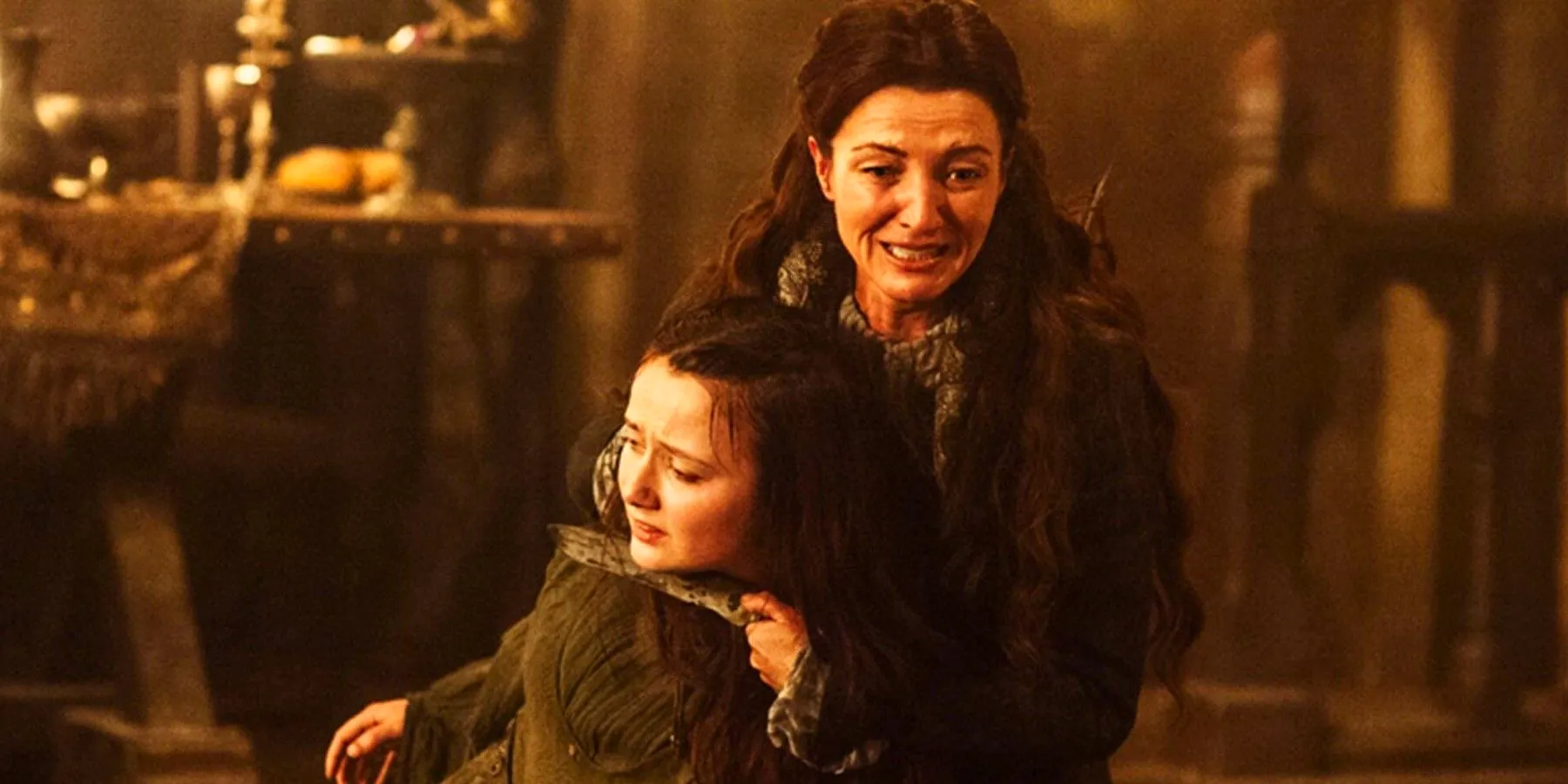 Michelle Fairley as Catelyn Stark holding Frey's wife and screaming at the Red Wedding in Game of Thrones Image