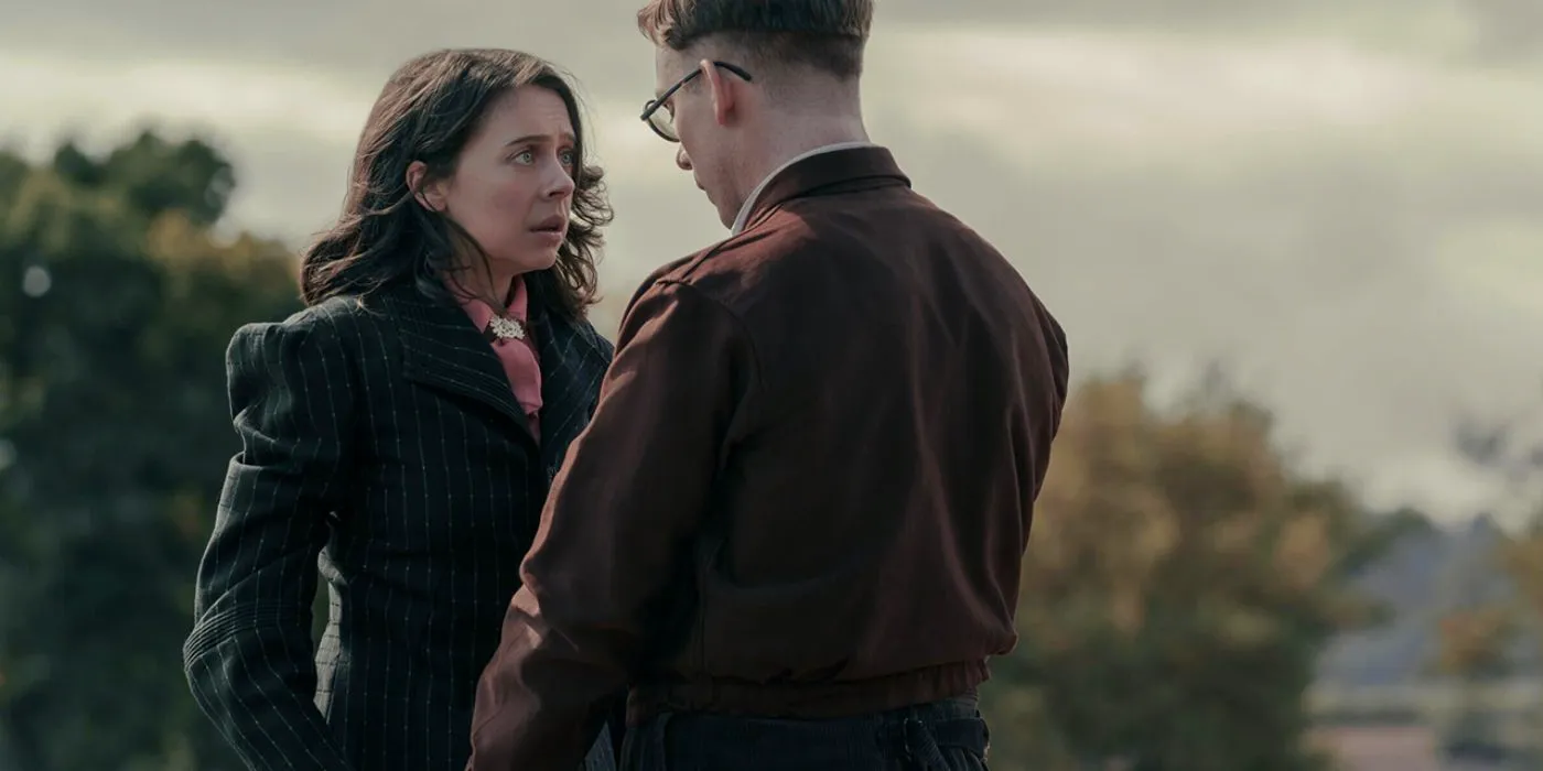 Miep (Bel Powley) and Jan Gies (Joe Cole) holding each others hands and looking scared in A Small Light. Image