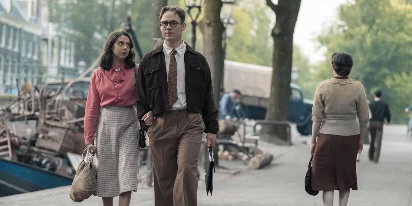 Miep (Bel Powley) and Jan Gies (Joe Cole) walking down the street arm in arm in A Small Light. Image