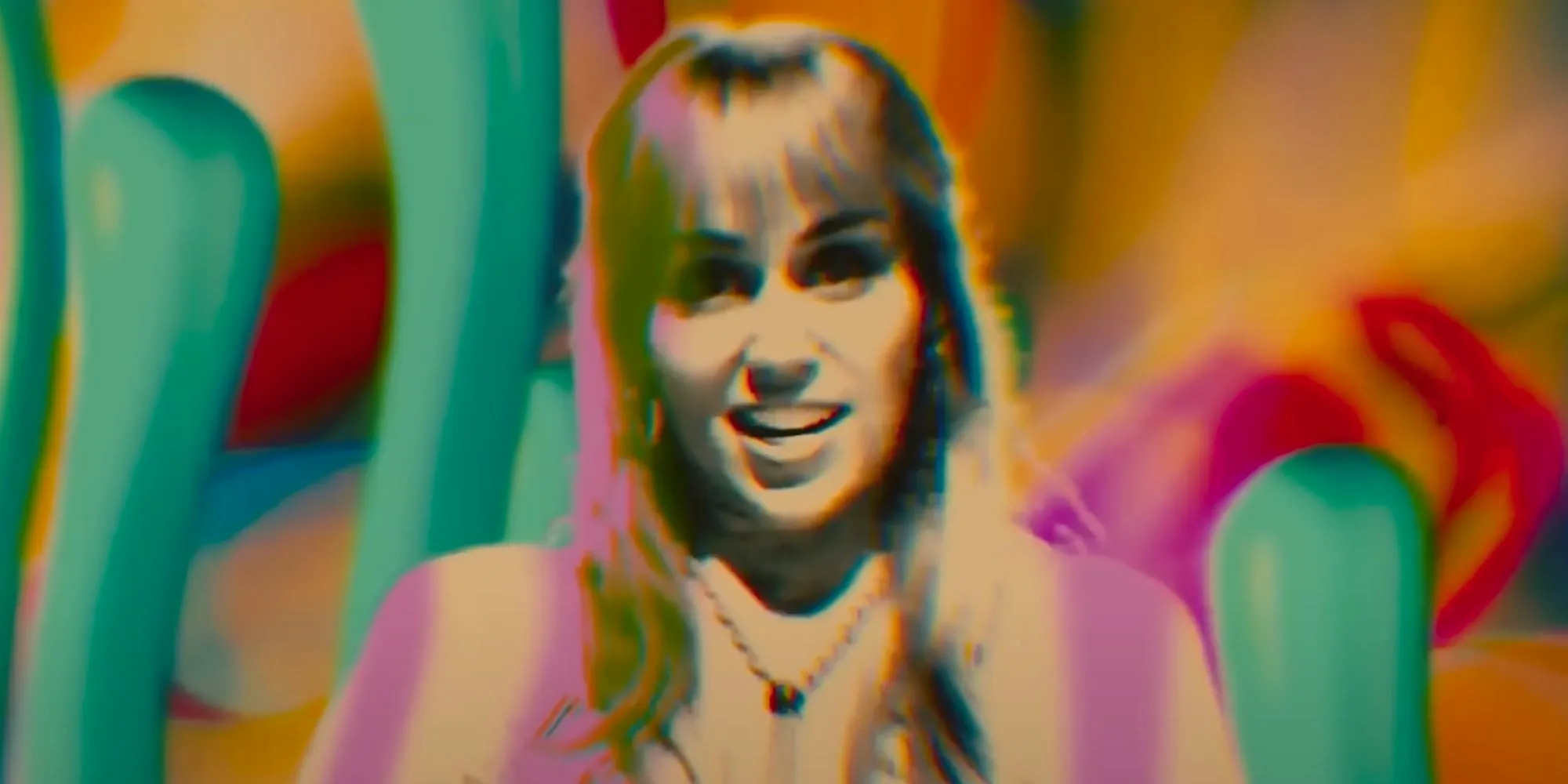 Miley Cyrus as Tiffany Plastercaster with a psychedelic background in Drive-Away Dolls Image