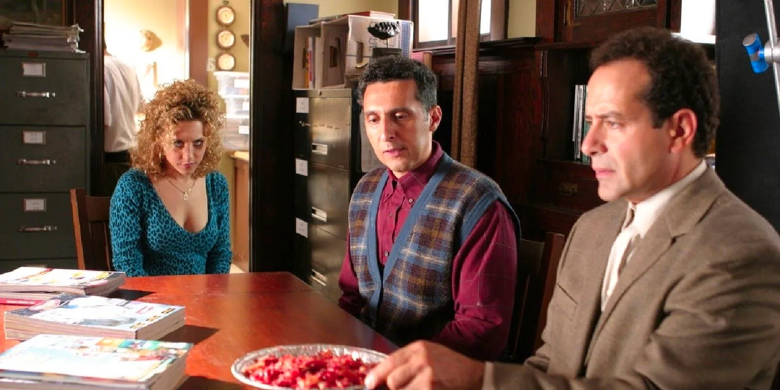 Monk and his brother with a pie in front of them while Sharona sits nearby in the series Monk Image