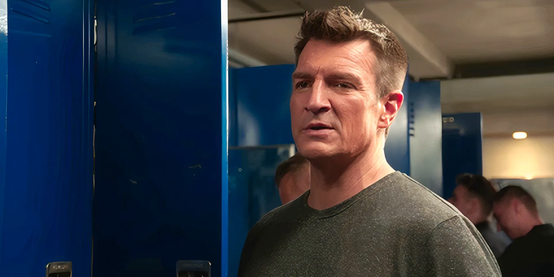 Nathan Fillion as John Nolan at his locker talking in The Rookie season 7 Image