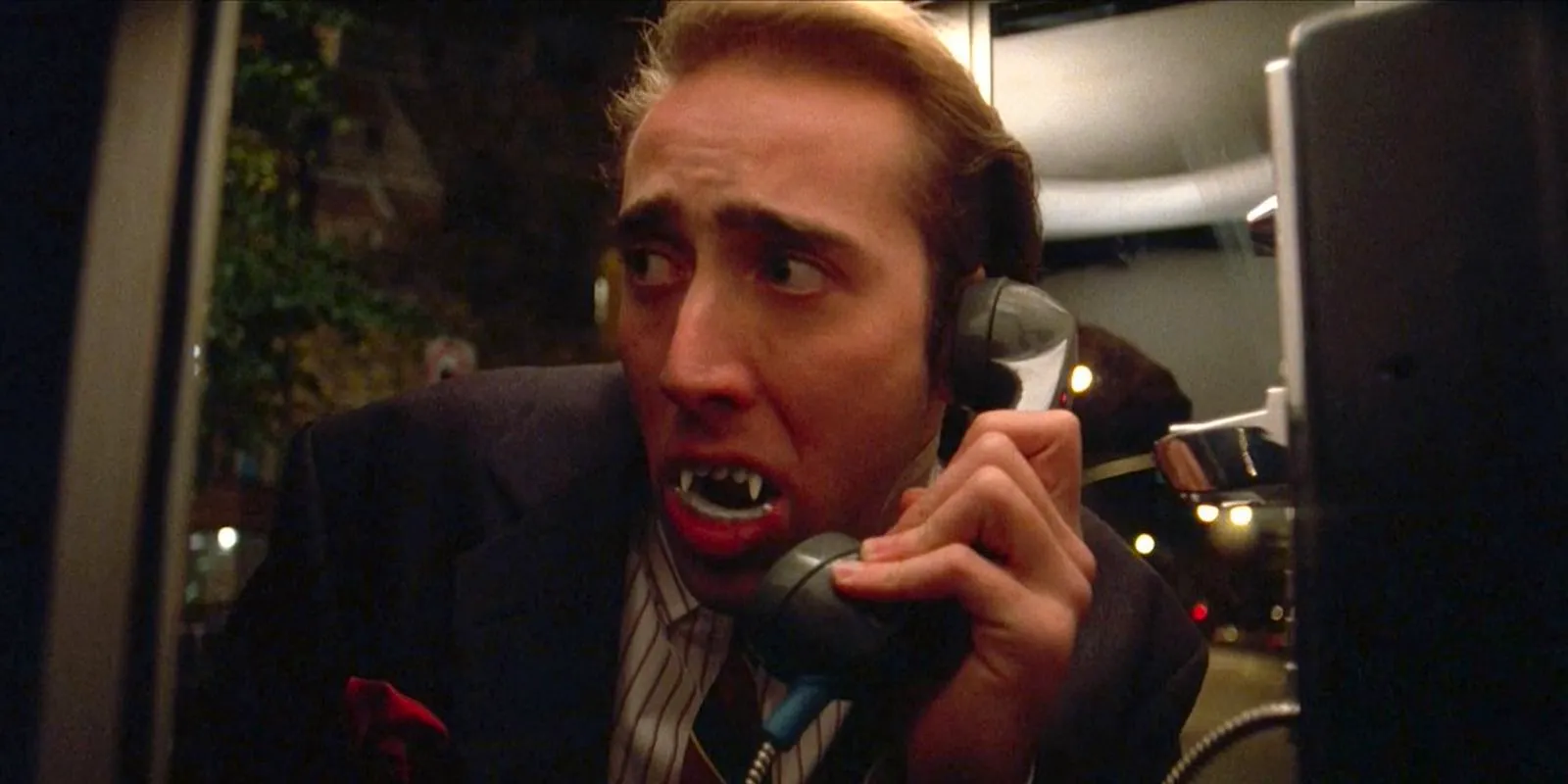 Nicolas Cage as Peter Loew wearing fake vampire teeth in Vampire's Kiss Image