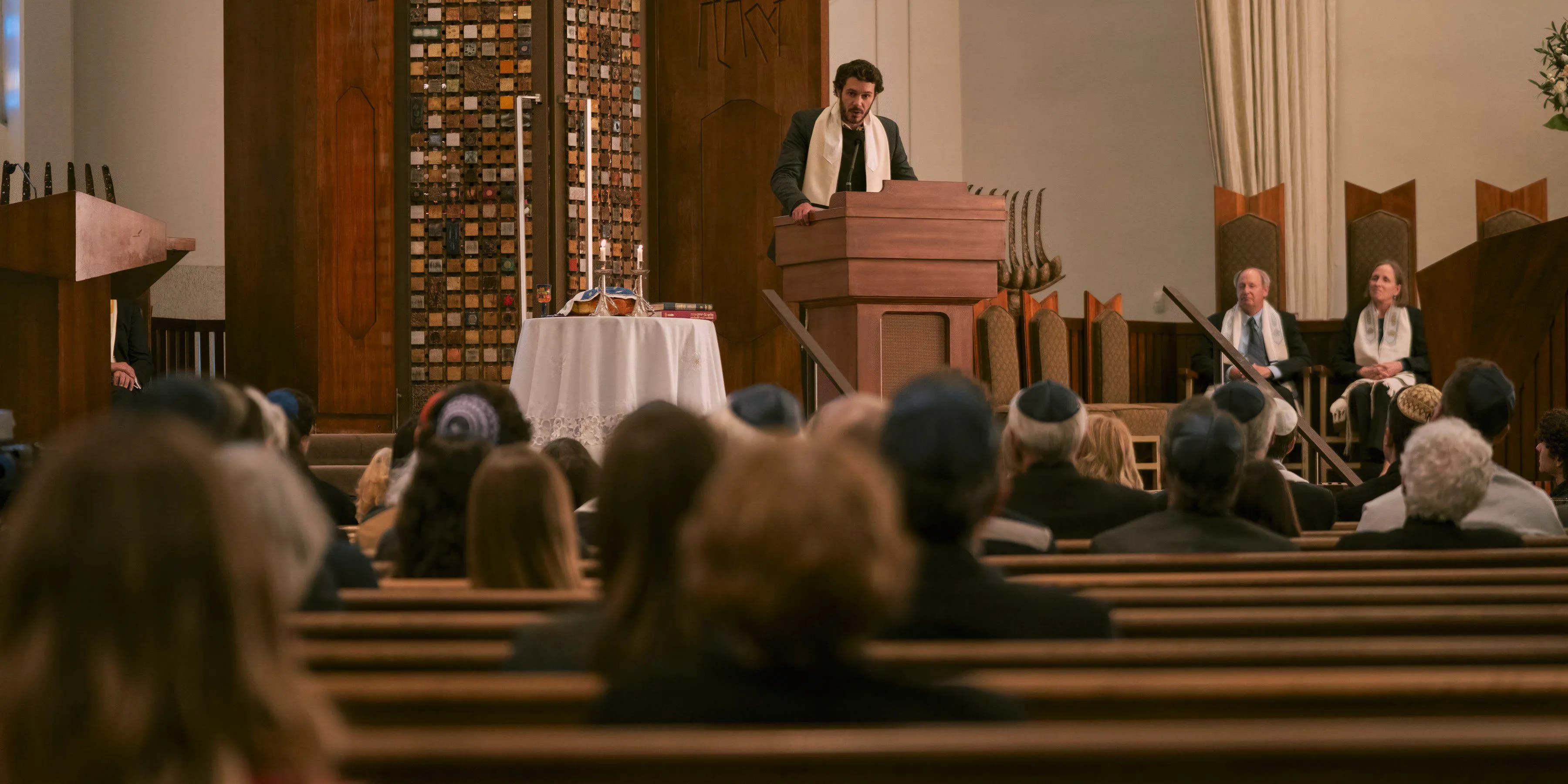 Noah gives a sermon in front of the temple members in Nobody Wants This. Image