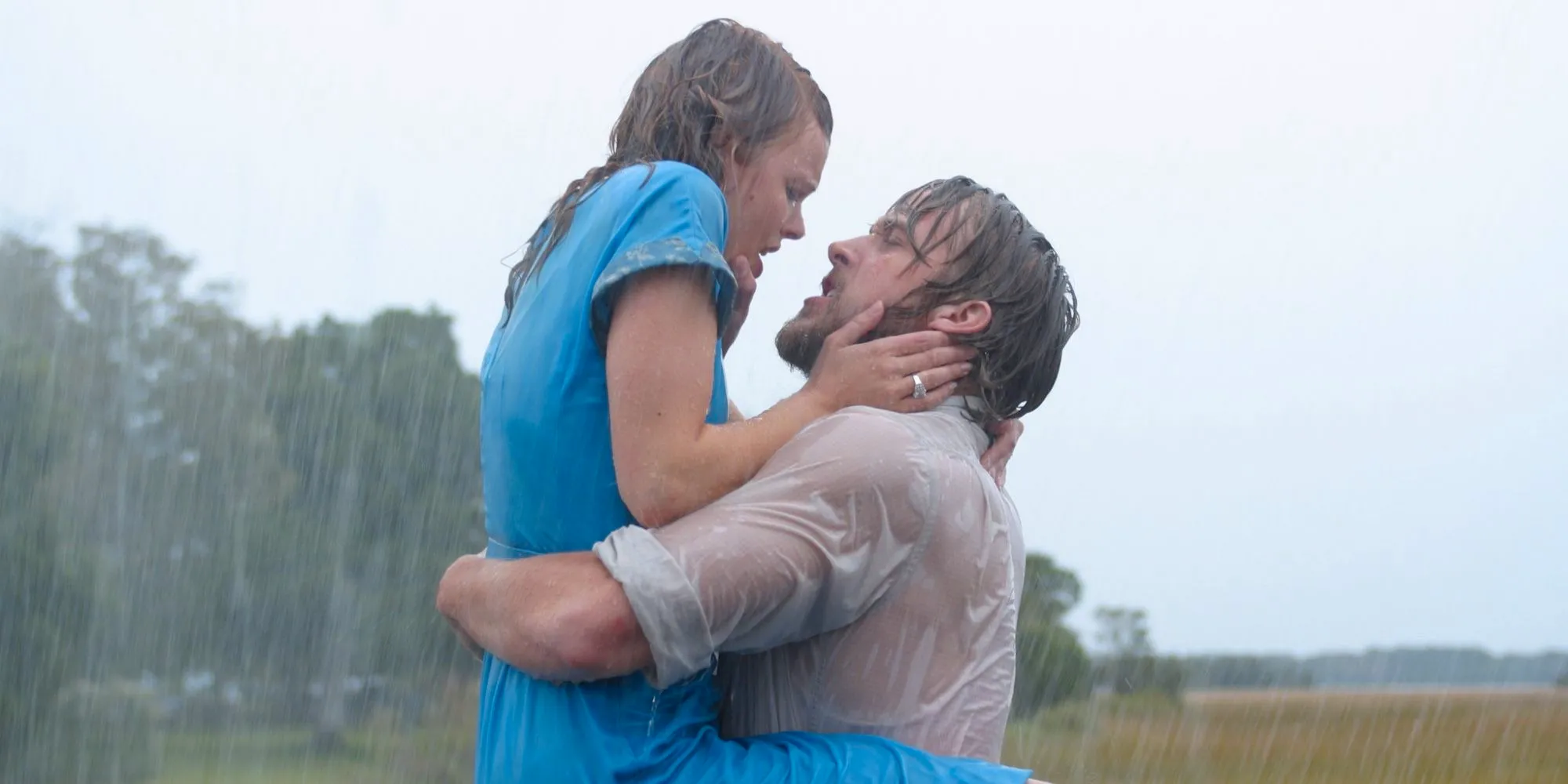 Noah (Ryan Gosling) holding Allie (Rachel McAdams) in his arms as they embrace in the rain in The Notebook. Image