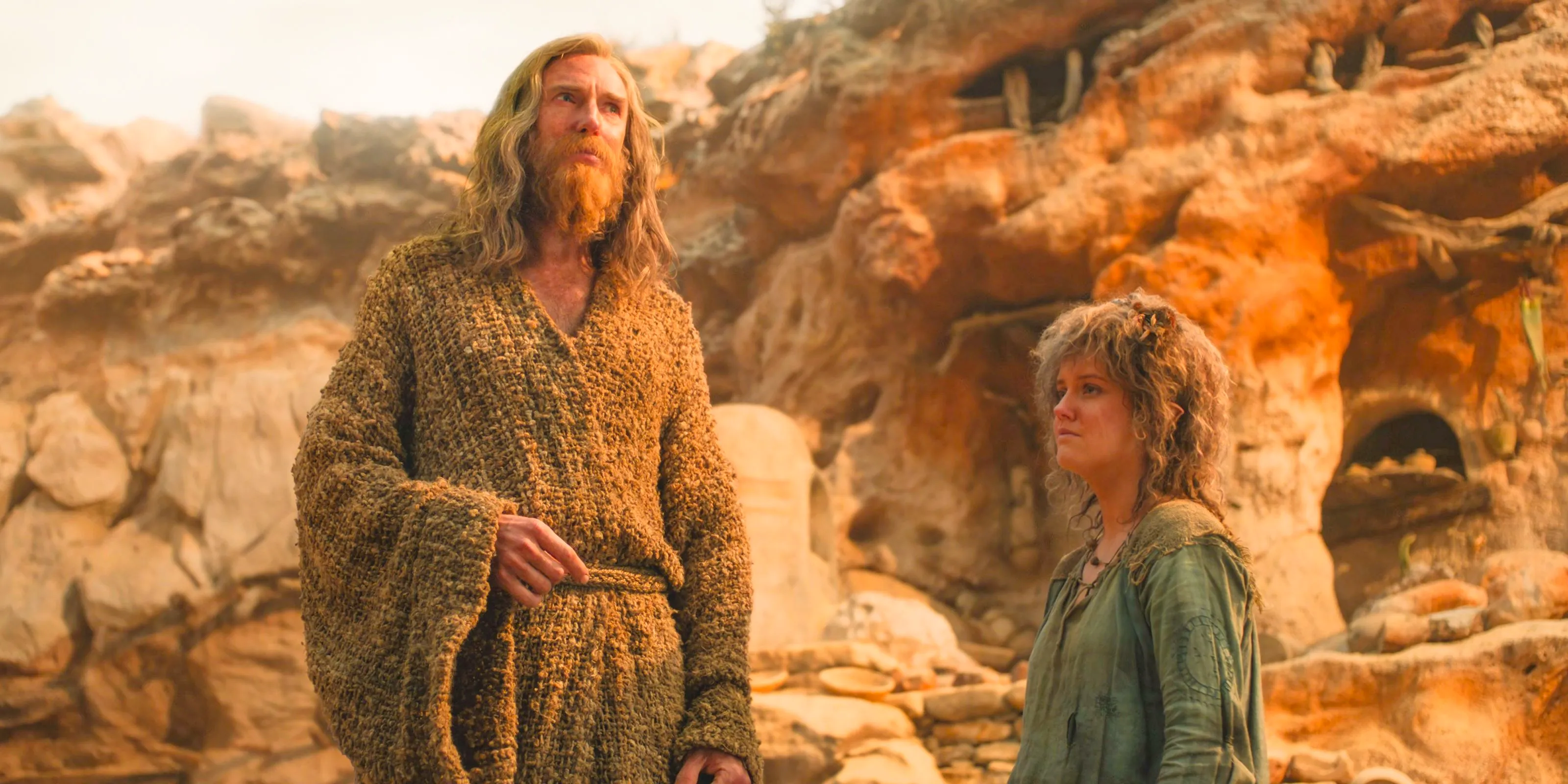 Nori (Markella Kavenagh) and The Stranger (Daniel Weyman) saddened by the destruction of the Stoors' village in The Lord of the Rings: The Rings of Power Season 2 Episode 8 Image