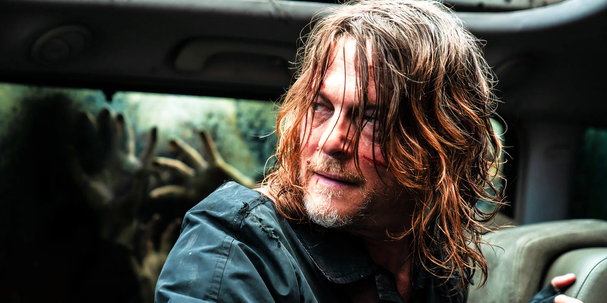 Norman Reedus as Daryl looking over his shoulder while inside a car in Daryl Dixon season 2 Image