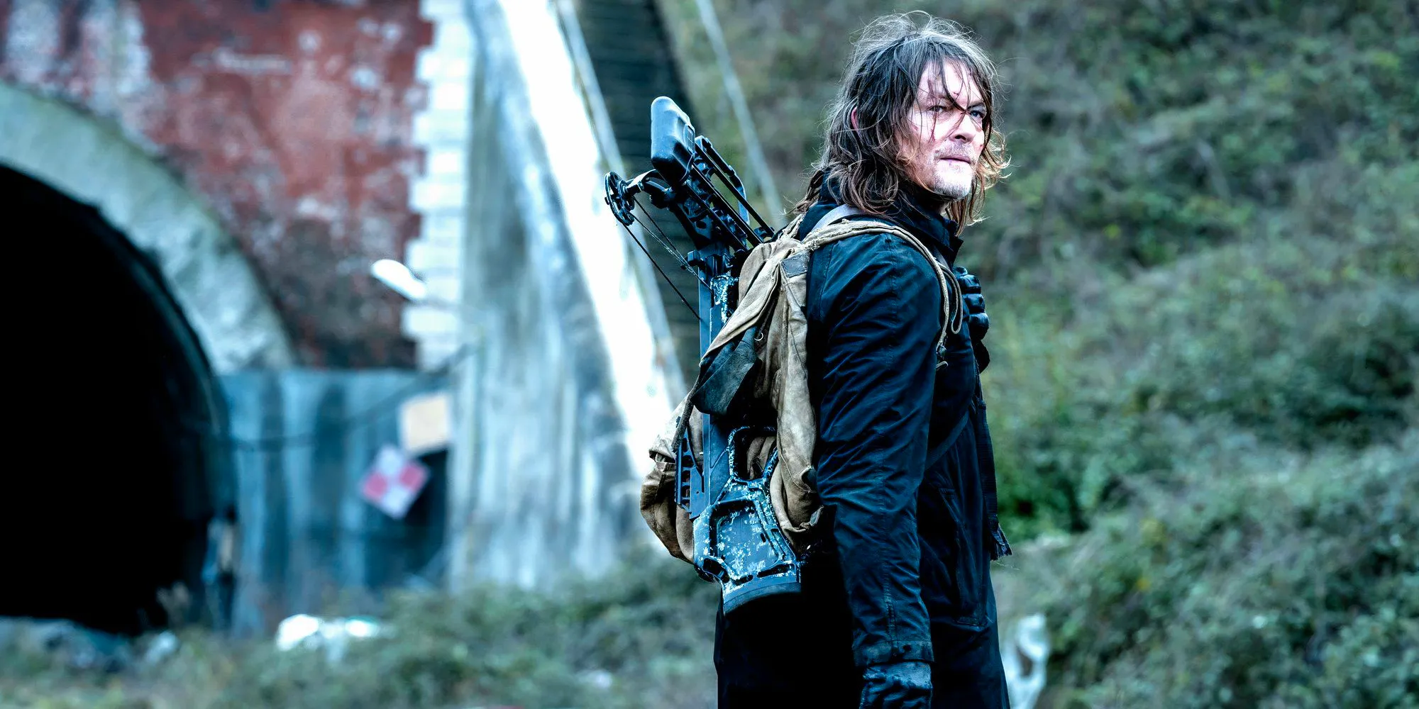 Norman Reedus as Daryl standing in front of a tunnel entrance in Daryl Dixon season 2 Image