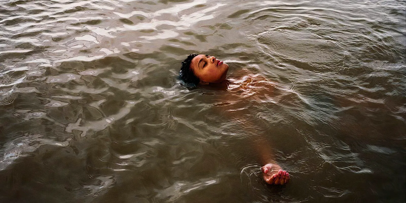 Nyika Adams as Bailey swimming in water in Bird movie still 2024 Image